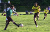 Adam Lancashire of Espo kicking the ball into the legs of Cesar Galea of Hamptons Arsenal
